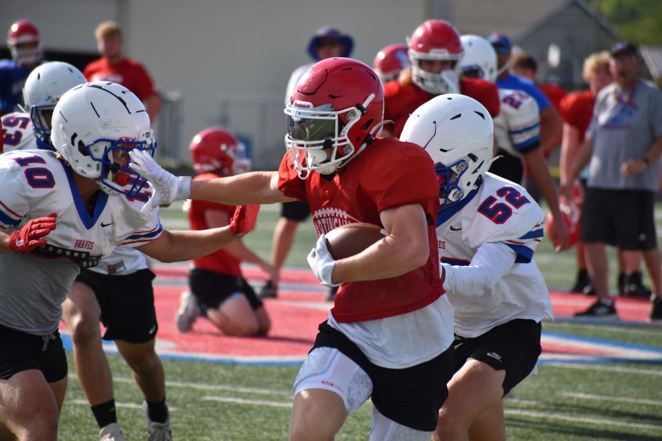 Martinsville's Brayden Shrake stiff arms an Indian Creek defender during the Artesians' scrimmage with the Braves on June 22, 2022.