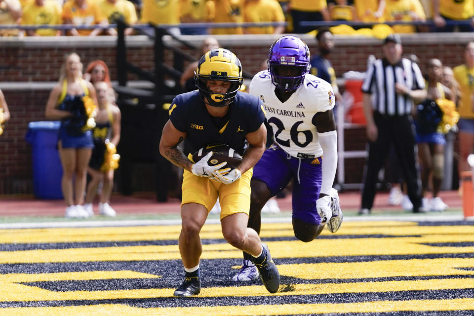 Michigan wide receiver Roman Wilson (1) catches a touchdown pass as East Carolina defensive back Isaiah Brown-Murray (26) defends in the first half of an NCAA college football game in Ann Arbor, Mich., Saturday, Sept. 2, 2023. (AP Photo/Paul Sancya)