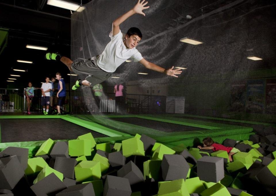 A young man jumps into a foam pit at a Launch Trampoline Park.