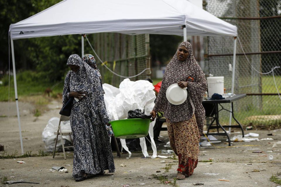 People gather Monday, June 17, 2019 to retrieve items left behind after a gunman opened fire Sunday evening, at Paschall Playground in Southwest Philadelphia. (AP Photo/Matt Rourke)