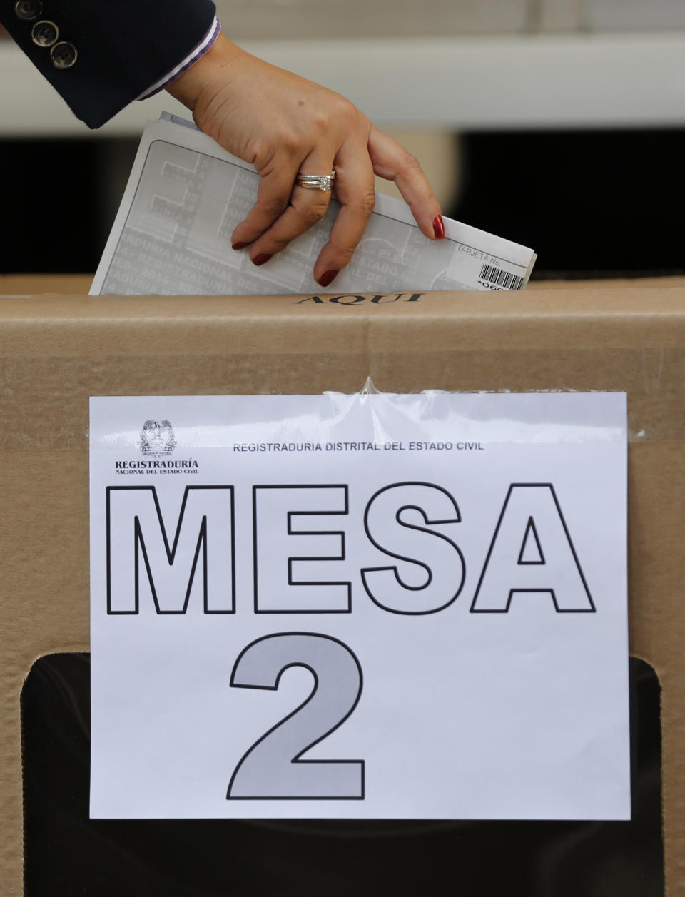 A woman casts her vote in a box that reads in Spanish "Table 2" during legislative elections in Bogota, Colombia, Sunday, March 9, 2014. (AP Photo/Fernando Vergara)