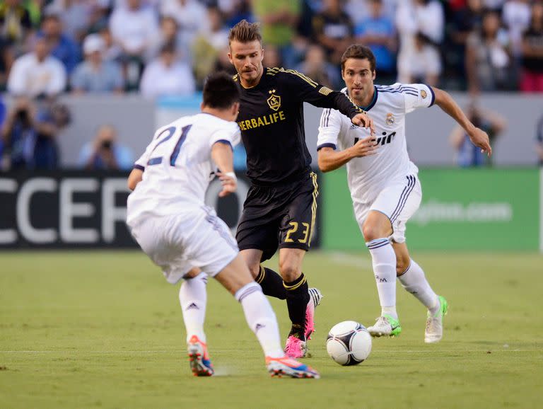 David Beckham domina la pelota y lo persigue Gonzalo, en California, en 2012, en una pretemporada, cuando el inglés jugaba en LA Galaxy; compartieron un título en 2006/2007 en Real Madrid y ahora los reúne la MLS como patrón y estrella de Inter Miami  