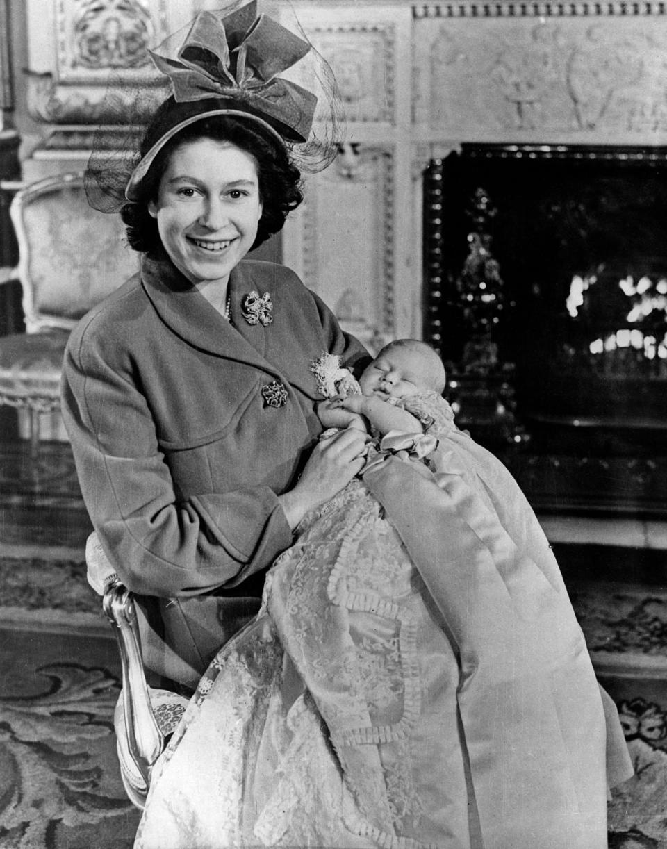 Prince Charles, 1948: The Queen was photographed holding her firstborn child, Prince Charles of Edinburgh (as he was known at the time), at Buckingham Place following his christening on 15 December 1948.The ceremony was attended by Lady Brabourne, The Earl of Athlone, and Princess Margaret and took place in the Palace’s music room, rather than the traditional location of the Private Chapel which had been damaged a few years before during World War II. (AFP/Getty Images)