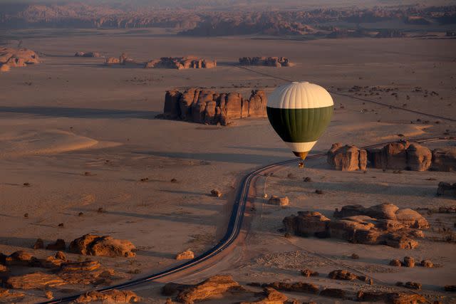 <p>almozinisaleh/Getty Images</p> Hot air balloon over Saleh Hegra site in Alula, Saudi Arabia.