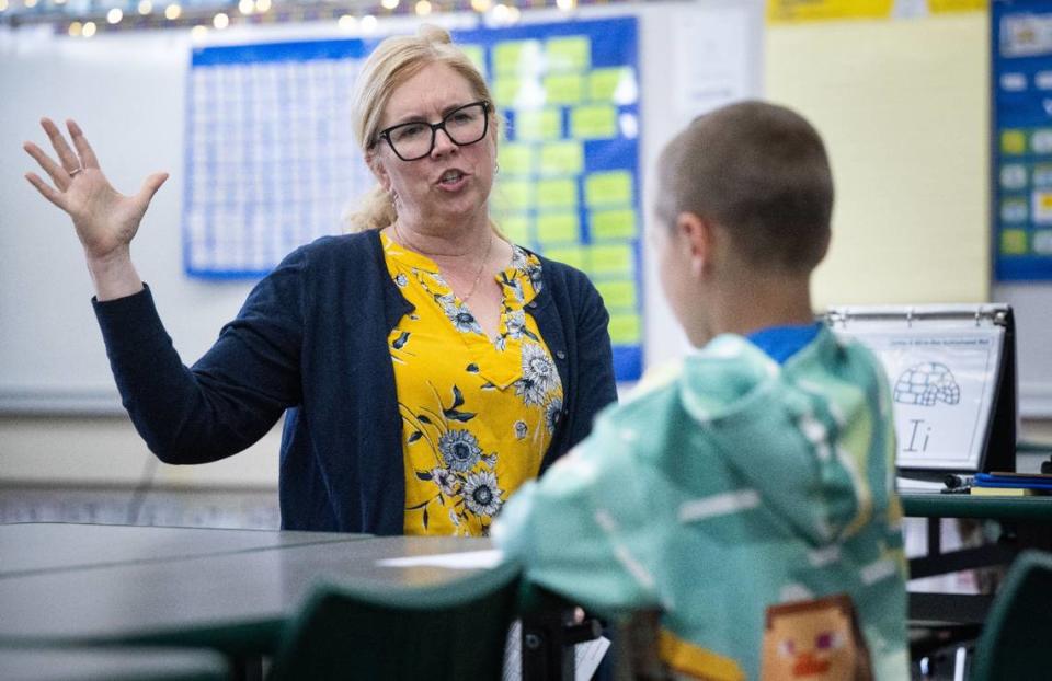 Second grader Jaxon, 8, is tutored in reading by instructional assistant Brittney Groess on Thursday at Thomas Kelly Elementary.