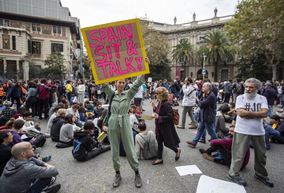 Catalan pro-independence protesters demonstrate outside the building of the Government Delegation in the Autonomous Community of Catalonia, in downtown Barcelona, Spain Monday, Oct. 21, 2019. Spanish leader Pedro Sanchez is traveling to Barcelona Monday, the protest-struck capital of the northeastern Catalonia region, to visit with injured police officers and talks with officials in charge of security. (AP Photo/Ben Curtis)