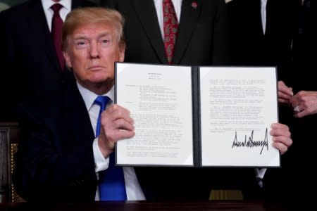 FILE PHOTO: U.S. President Donald Trump holds his signed memorandum on intellectual property tariffs on high-tech goods from China, at the White House in Washington, U.S. March 22, 2018.  REUTERS/Jonathan Ernst/File Photo