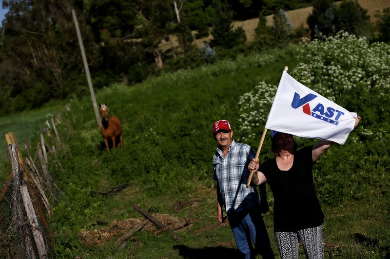 Supporter of Chilean presidential candidate Jose Antonio Kast holds a flag before attending a campaign rally in Yumbel