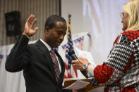 Mike Elliott takes the oath of office as the city's new mayor with city clerk Barb Suciu, right, during Elliot's inauguration ceremony, Wednesday, Jan. 2, 2019, at the Brooklyn Center Community Center, in Brooklyn Center, Minn. Elliott is the city's first Black and first Liberian American mayor. Elliott, who emigrated from Liberia as a child, is finding just how difficult it is to turn the page on the nation’s racial history as he handles the fallout from a police shooting. (Aaron Lavinsky/Star Tribune via AP)