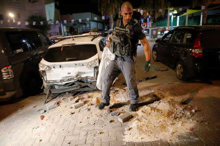 An Israeli policeman surveys the scene where a rocket exploded in the southern city of Sderot, Israel August 8, 2018. REUTERS/Amir Cohen
