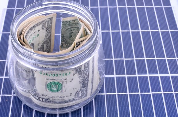 A jar of money on top of a solar panel