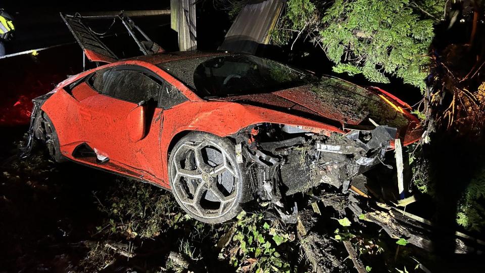 a red car parked in a wooded area