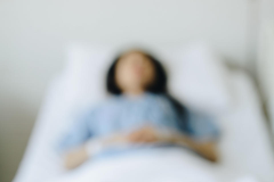 Blurry photo of someone lying in bed on their back