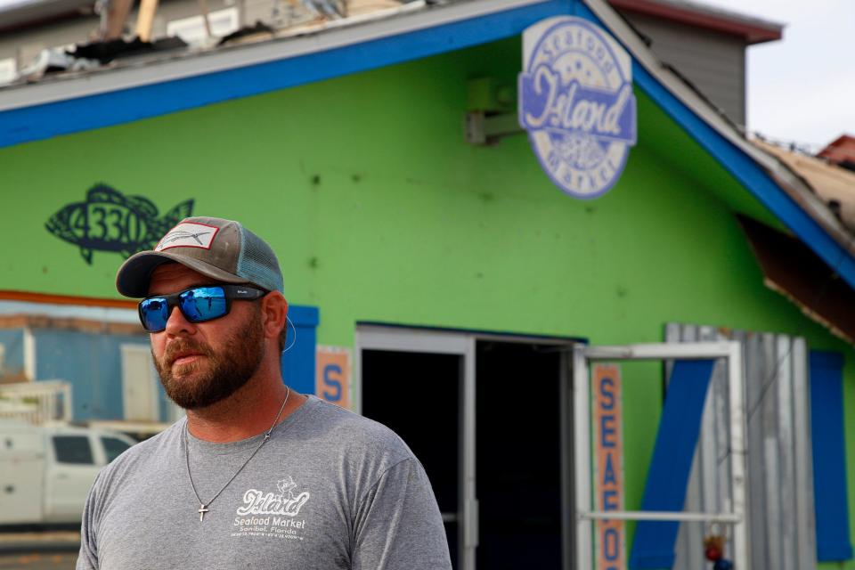 Island Seafood Market owner Casey Streeter on Tuesday stands outside of his business, which sustained extensive damage from Hurricane Ian in Matlacha, Fla. "This is where people of Southwest Florida, Cape Coral, Fort Myers and the surrounding areas come to get access to fish and crabs off boats," he said, adding that they can't lose the history of the island. "We're at ground zero right now, for the storm and for what a rebuild looks like for all of our working waterfronts moving forward."