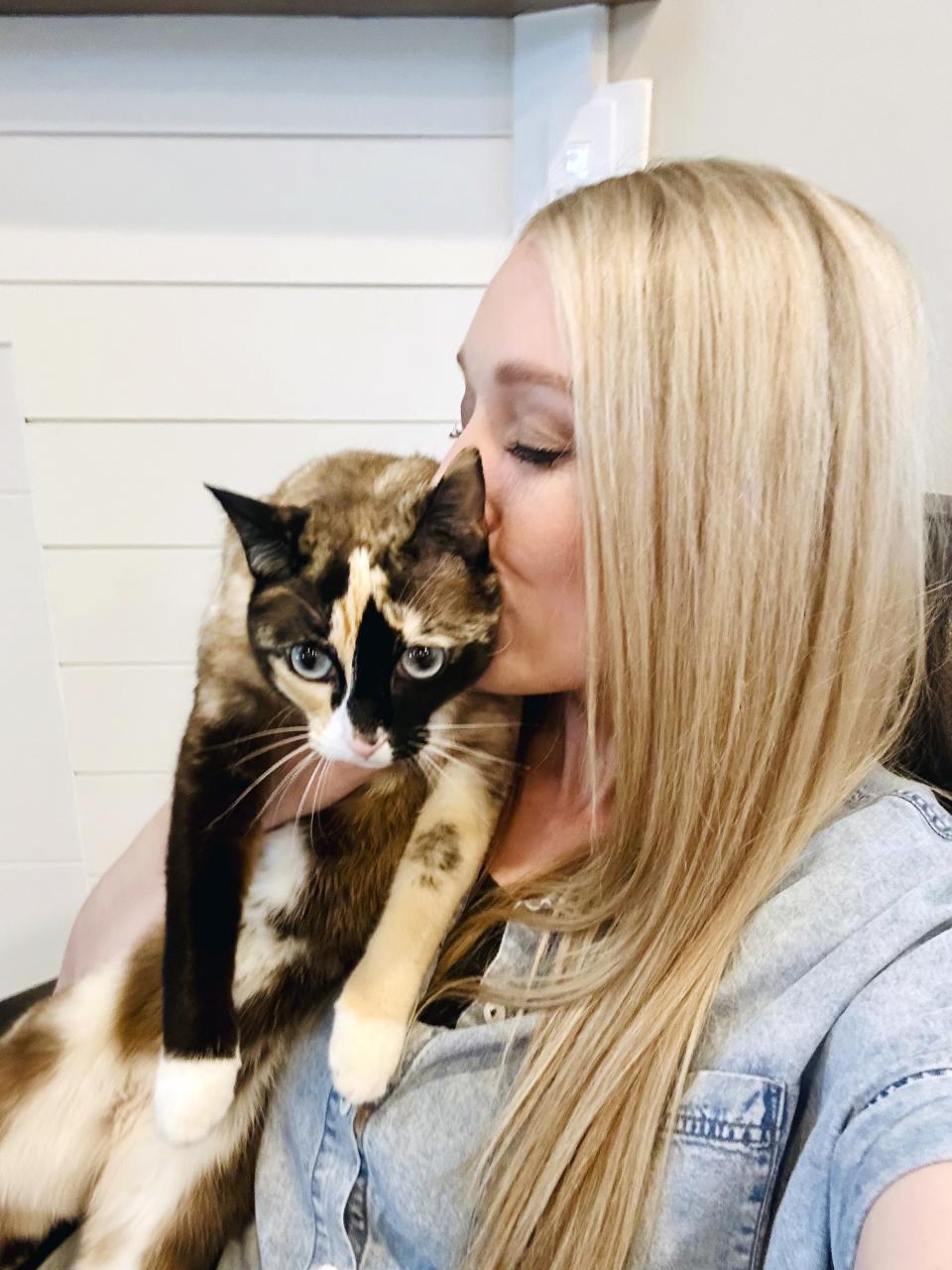 In this photo provided by Carrie Clark of Lehi, Utah, Carrie poses with Galena, a 6-year-old house cat. Clark says Galena went missing after jumping into a box being returned to Amazon without its owners noticing. (Carrie Clark via AP Photo)