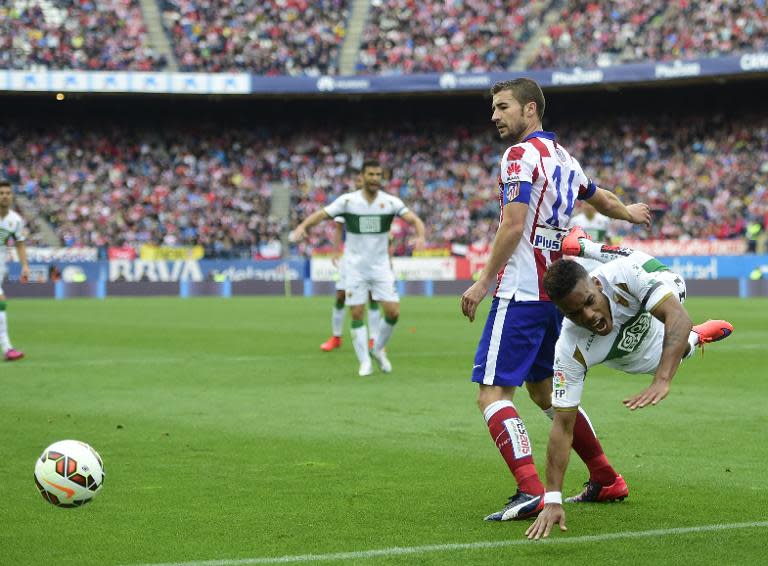 Atletico Madrid's Gabi (L) competes for the ball with Elche's Garry Mendes Rodrigues during their Spanish La Liga match against Elche, at the Vicente Calderon stadium in Madrid, on April 25, 2015