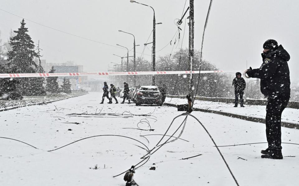 A policeman in Zaporizhzhia sets up a cordon around the site of a strike