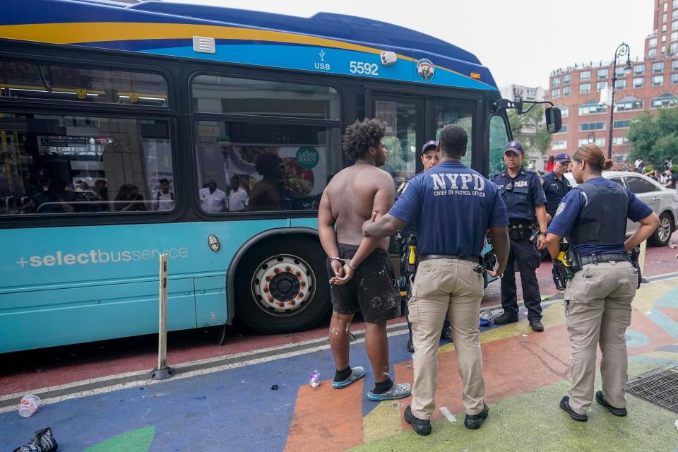 Police officers arrest a man, Friday, Aug. 4, 2023, in New York's Union Square. Police in New York City struggled to control a crowd a crowd of thousands of people who gathered in Manhattan's Union Square for an Internet personality's videogame console giveaway that got out of hand.