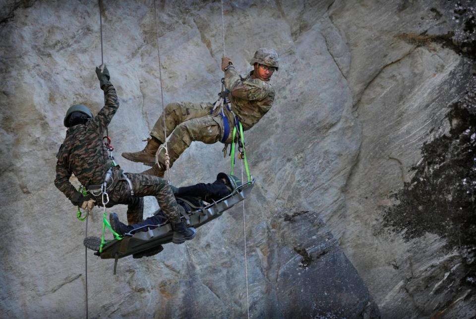 US army soldiers of the Second Brigade of the 11th Airborne Division with Indian army soldiers carry out a mock drill of bringing down an injured villager under humanitarian assistance (AP)