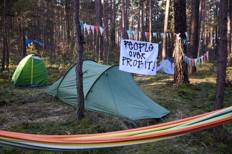 A banner reading "People over profit!" is seen at a camp set up by the "Stop Tesla" initiative in a pine forest near the Tesla Gigafactory Berlin-Brandenburg. The aim of the activists is to prevent the forest from being cleared as part of a planned expansion of the Tesla site with a freight yard. Joerg Carstensen/dpa