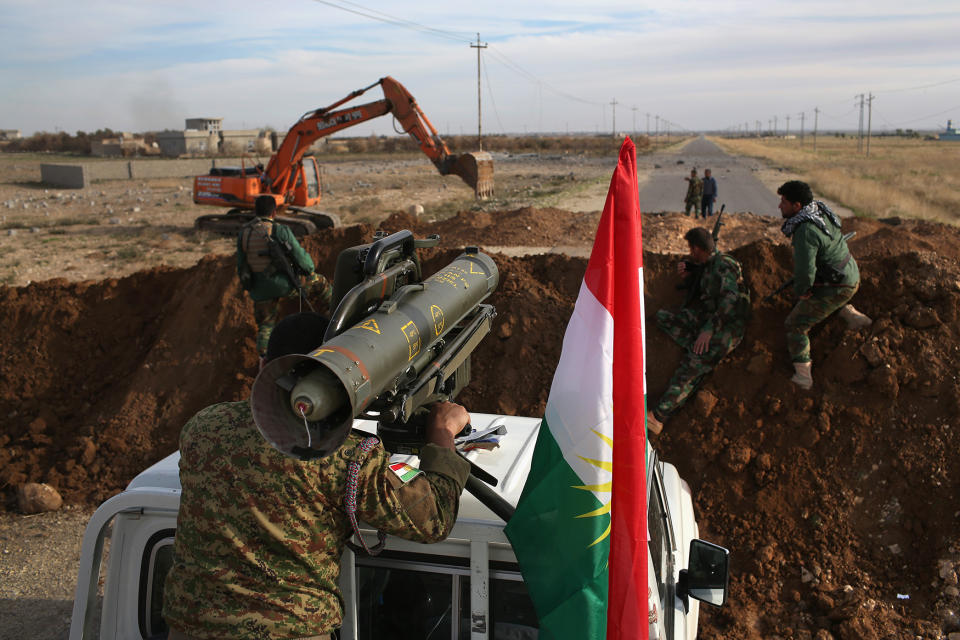 A Kurdish fighter aims an anti-tank missile toward an ISIS position as a bulldozer builds berms and trenches on the new frontline on November 15, 2015, near Sinjar, Iraq. (John Moore/Getty Images)