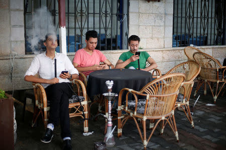 Palestinians smoke shisha or hookah (waterpipe) at a coffee shop in Gaza City. REUTERS/Suhaib Salem