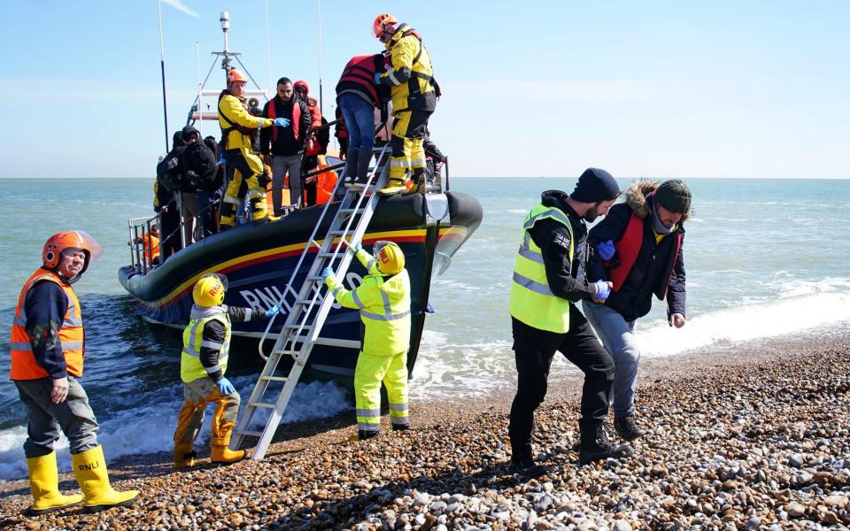 A group of people thought to be migrants arrive on the Kent coast after being rescued following a small boat incident in the Channel last April