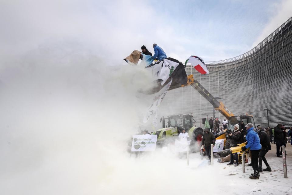European dairy farmers spray the EU Council building with milk powder to protest the crisis in their sector, in Brussels on Monday, Jan. 23, 2017. The sector has been hit with sagging prices and production costs squeezing profits to the extent that has driven many farmers to the brink of bankruptcy. The EU's executive Commission has approved some support measures over the past year, but the farmers fear that releasing more milk powder on the market would further complicate their plight. (AP Photo/Geert Vanden Wijngaert)