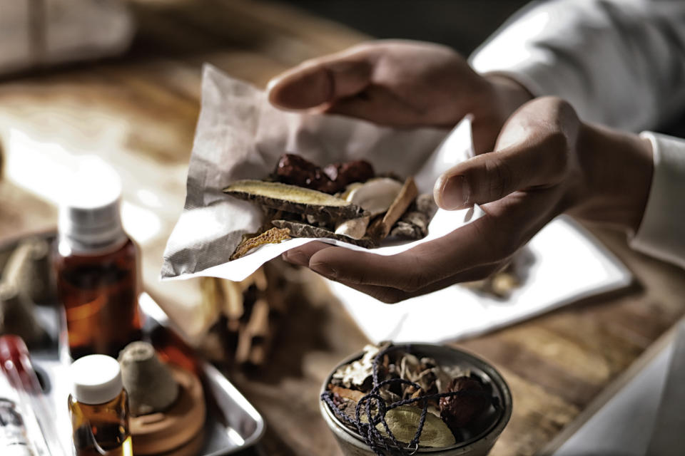 Oriental medical doctor with various dried herbal medicine