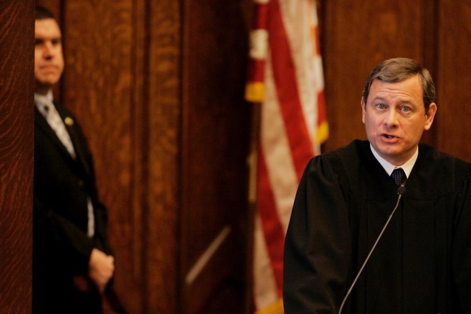 Supreme Court Chief Justice John G. Roberts, Jr., makes remarks at the opening celebration of the Centennial of the U.S. Courthouse in Providence, RI., as a member of his security team looks on Tuesday morning, Feb. 12, 2008.