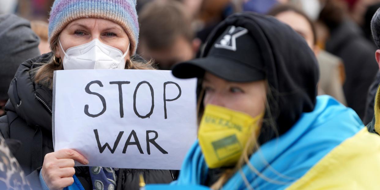 A protester holds a sign that says "Stop war."