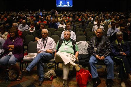 Berkshire Hathaway shareholders listen to CEO Warren Buffett and vice-chairman Charlie Munger seen on a projection screen in the background at the annual meeting in Omaha, Nebraska May 3, 2014. REUTERS/Rick Wilking