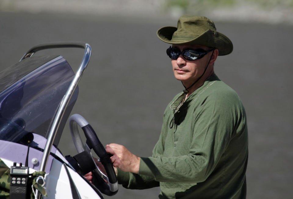 Putin stands at the wheel of a motorboat in Tyva on Aug. 3, 2009.