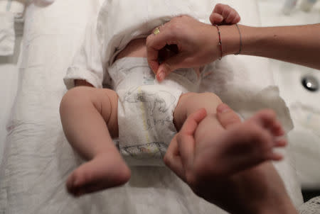 A woman adjusts her baby's diaper in Nice as a study by the French environment agency ANSES indicated that a variey of potentially toxic substances have been found in babies' nappies in France, January 23, 2019. REUTERS/Eric Gaillard