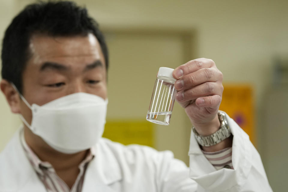 University of Tokyo radiologist Katsumi Shozugawa holds water containing tritium during an interview with The Associated Press, at the university in Tokyo on Feb. 16, 2023. Shozugawa said his analysis of groundwater in multiple locations in no-go zones near the plant has shown that tritium and other radioactive elements have been leaking into groundwater. (AP Photo/Shuji Kajiyama)