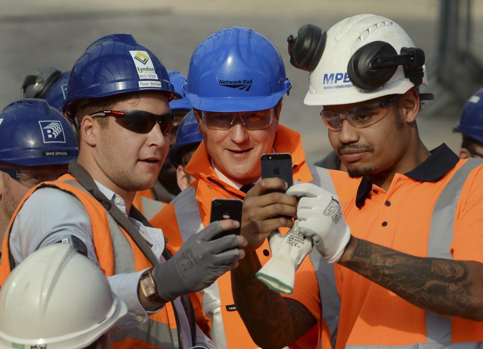 Britain's Prime Minister David Cameron poses for selfie photographs during his visit to the redevelopment of New Street station in Birmingham