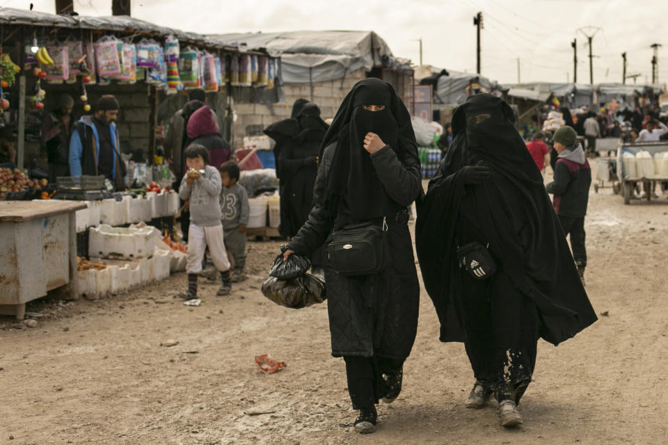 FILE - Women shop in the marketplace at al-Hol camp, home to families of Islamic State fighters, in Hasakeh province, Syria, on March 31, 2019. Iraq is stepping up repatriation of its citizens from a camp in northeastern Syria housing tens of thousands of people, mostly wives and children of Islamic State fighters but also supporters of the militant group. It’s a move that Baghdad hopes will reduce cross-border militant threats and eventually lead to shutting down the facility. (AP Photo/Maya Alleruzzo, File)