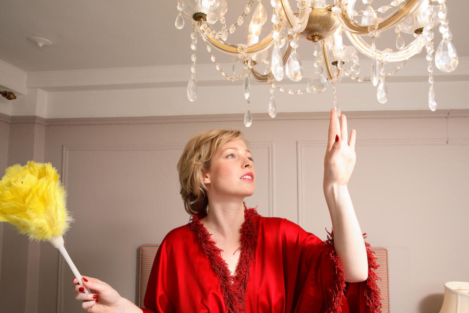 Woman dusting chandelier