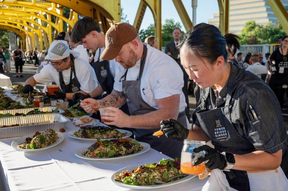 Chefs prepare the second course, furikake-crusted albacore tuna with mixed heirloom rice, at the Tower Bridge Dinner on the Tower Bridge between Sacramento and West Sacramento on Sunday.