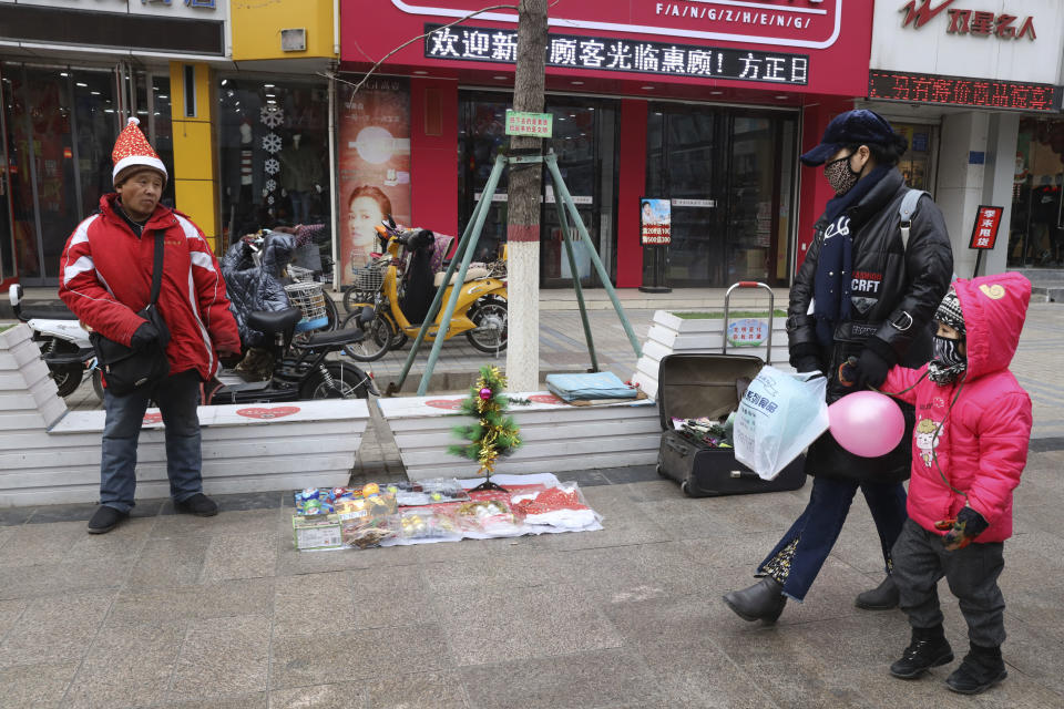 In this Saturday, Dec. 22, 2018, photo, a man sells Christmas decorations on a street of Zhangjiakou in northern China's Hebei province. At least four Chinese cities and one county have restricted Christmas celebrations this year. Churches in another city have been warned to keep minors away from Christmas, and at least ten schools nationwide have curtailed Christmas on campus, The Associated Press has found. (AP Photo/Ng Han Guan)