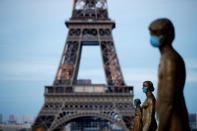 FILE PHOTO: Golden Statues at the Trocadero square near the Eiffel tower wear protective masks during the outbreak of the coronavirus disease