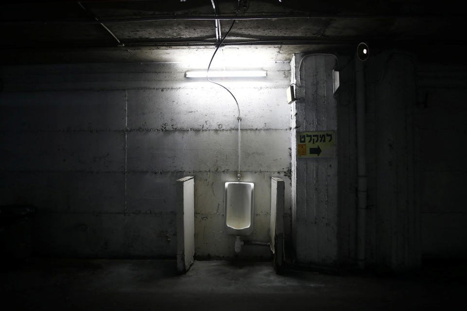 A urinal in the basement near a sign pointing toward a bomb shelter at the Central Bus Station on May 25. (Photo: Corinna Kern/Reuters)