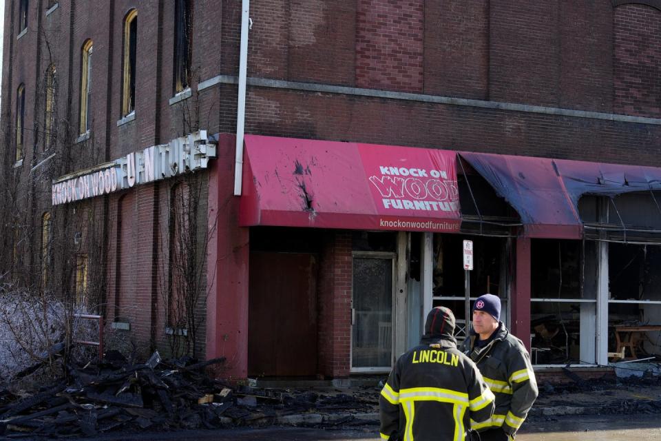 Fire officials on Friday at the scene of an overnight fire at the Knock on Wood Furniture store on Lonsdale Avenue in Lincoln.