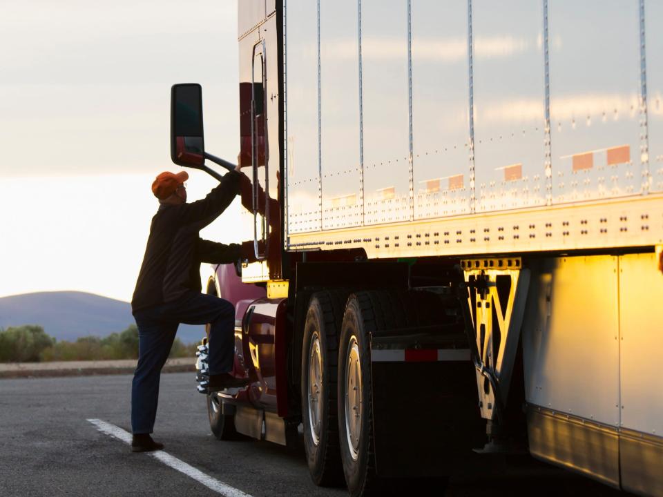 A truck driver getting into a truck