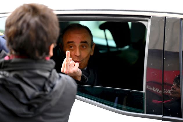 TOPSHOT - French far-right media pundit Eric Zemmour gestures towards a woman who insulted him as he leaves in his car after a visit in Marseille, southern France, on November 27, 2021. - Eric Zemmour, who is due to announce his candidacy for the presidential election in the next few days, made a last eventful visit to Marseille on November 26, a city he described as 