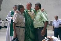 FILE - Monsignor Silvio Baez, center, auxiliary bishop of the Archdiocese of Managua, embraces members of the National Elderly Union, in the Metropolitan Cathedral in Managua, Nicaragua, June 23, 2013. Baez left the country in 2019 at the Vatican’s request, a transfer that was lamented by the opposition and celebrated by the ruling Sandinistas. (AP Photo/Esteban Felix, File)