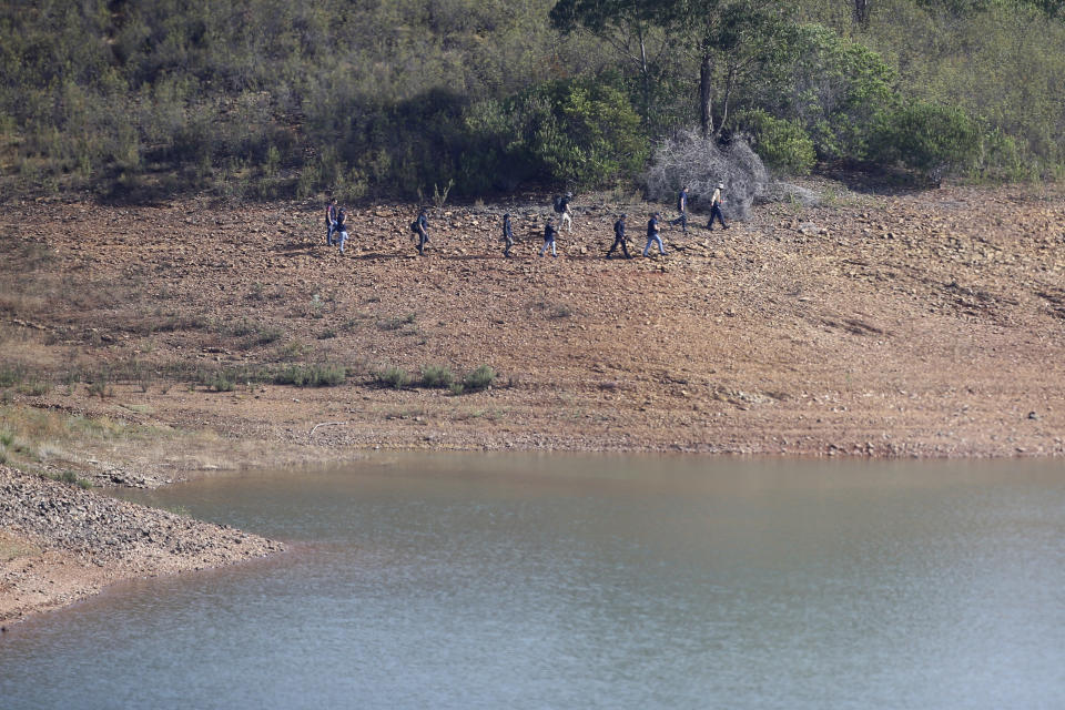 A police search team work on the shore of the Arade dam near Silves, Portugal, Wednesday May 24, 2023. Portuguese police aided by German and British officers have resumed their search for Madeleine McCann, the British child who disappeared in the country's southern Algarve region 16 years ago. Some 30 officers could be seen in the area by the Arade dam, about 50 kilometers (30 miles) from Praia da Luz, where the 3-year-old was last seen alive in 2007. (AP Photo/Joao Matos)