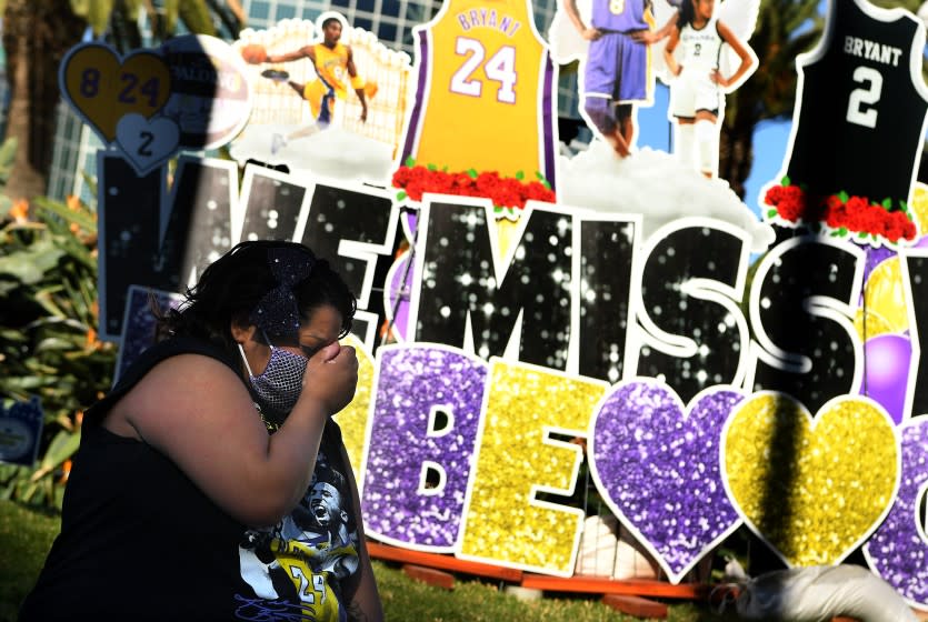 LOS ANGELES, CALIFORNIA JANUARY 26, 2021-A woman cries in front of a Kobe Bryant mural outside Staples Center on the 1-year anniversary of Kobe Bryant's death in Downtown Los Angeles Tueswday. (Wally Skalij/Los Angeles Times)