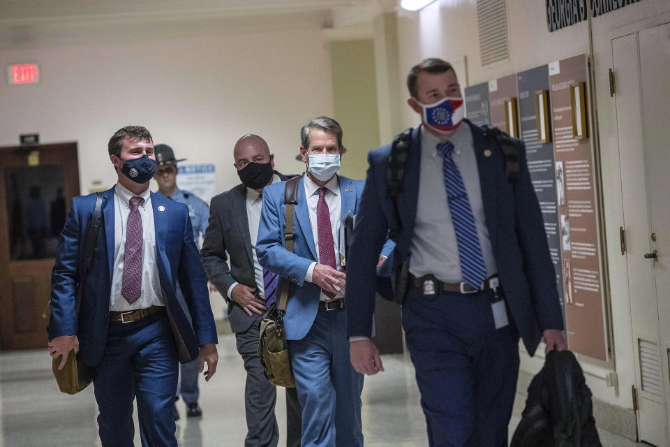 Georgia Gov. Brian Kemp, second from right, leaves the Georgia State Capitol Building after he signed into law a sweeping Republican-sponsored overhaul of state elections that includes new restrictions on voting by mail and greater legislative control over how elections are run, Thursday, March 25, 2021 in Atlanta. (Alyssa Pointer/Atlanta Journal-Constitution via AP)