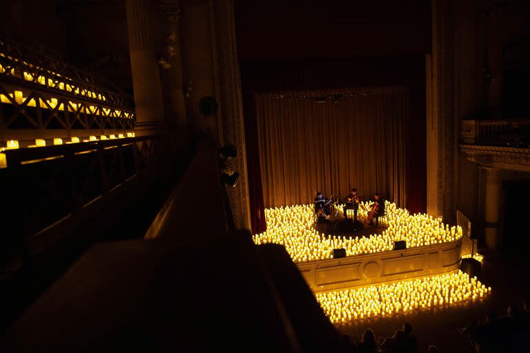 Un cuarteto de cuerdas iluminado a la luz de las velas en el teatro del Colegio San José